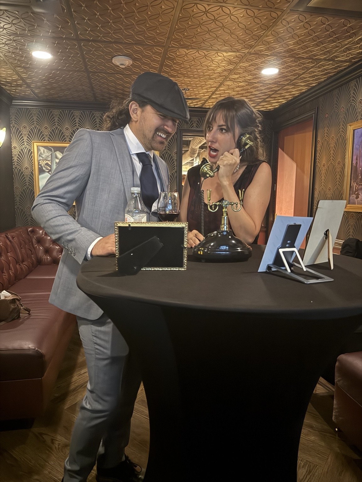 A woman speaking into the guestbook handset while a guest beside her laughs